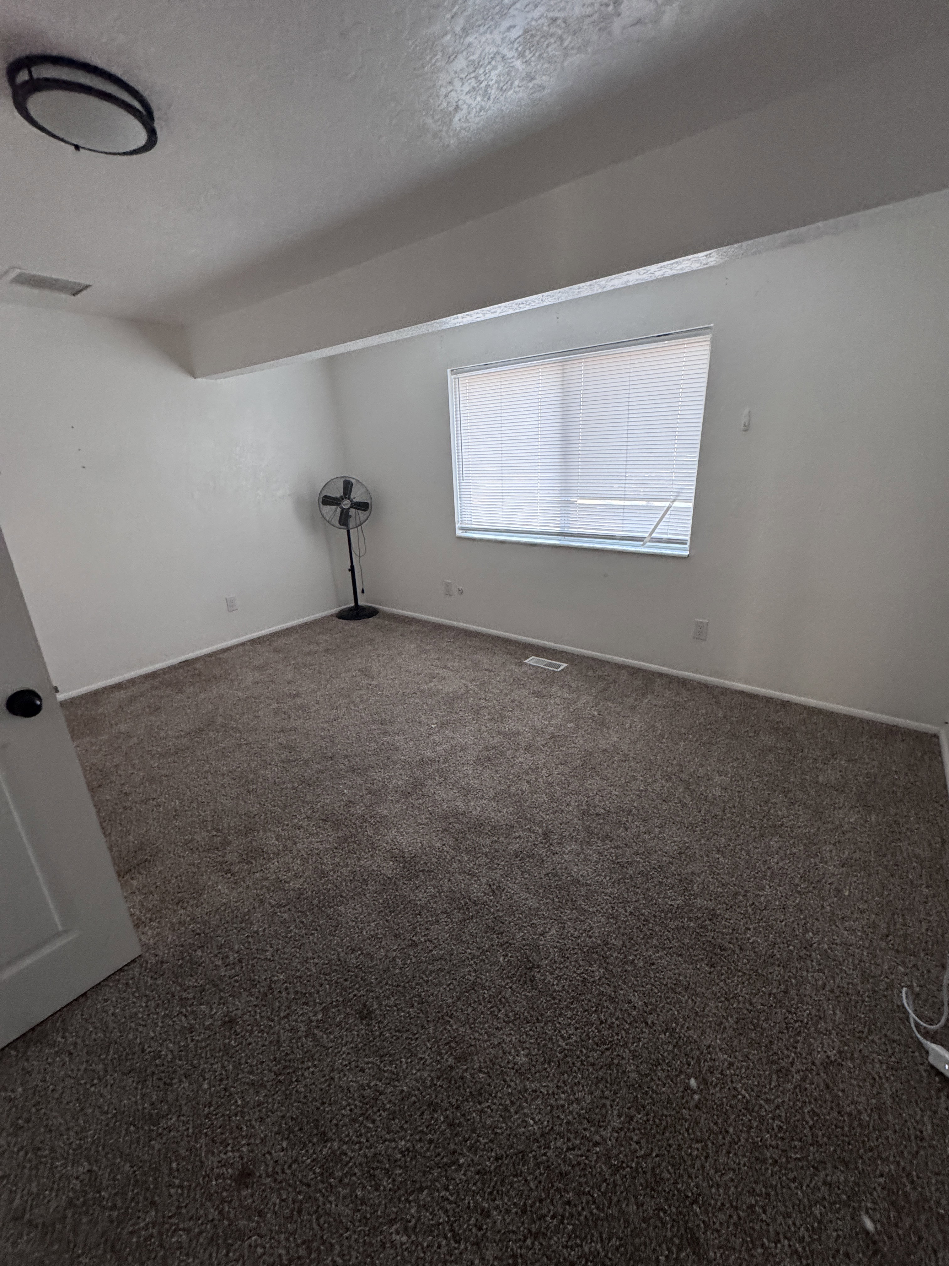 Spare room with a textured ceiling and carpet