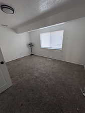 Spare room with a textured ceiling and carpet