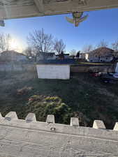 Fenced backyard featuring a residential view and a shed