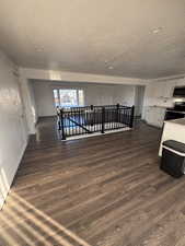 Kitchen featuring white cabinets, stainless steel appliances, dark wood-style flooring, light countertops, and a textured ceiling