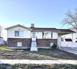 View of front of house featuring brick siding and a carport