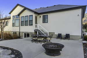 Back of house with a patio, a fire pit, stucco siding, and roof with shingles