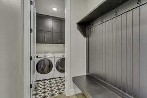 Laundry area featuring independent washer and dryer and cabinet space