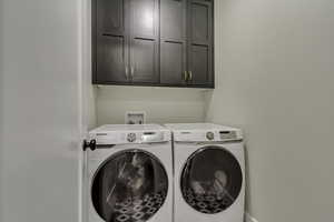 Washroom with cabinet space and washing machine and dryer