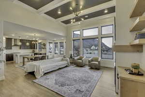 Living room with a chandelier, light wood-style flooring, beamed ceiling, coffered ceiling, and recessed lighting