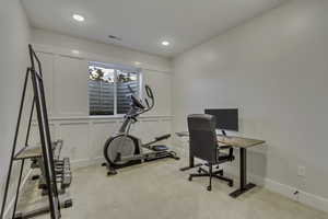 Office area featuring a decorative wall and light carpet