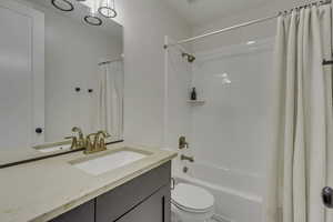 Bathroom featuring shower / tub combo with curtain and vanity