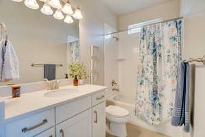 Full bath with shower / bathtub combination with curtain, vanity, and tile patterned floors