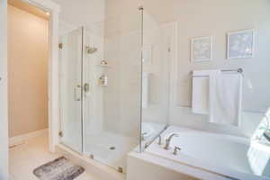 Bathroom with a bath, a shower stall, and tile patterned flooring