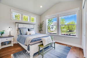 Bedroom with lofted ceiling, dark wood-style floors, and recessed lighting