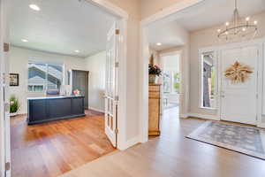Entryway with light wood finished floors, healthy amount of natural light, a chandelier, and recessed lighting