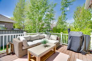Wooden terrace with a grill and an outdoor living space