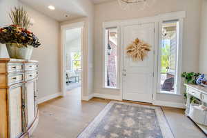 Foyer entrance with light wood-style flooring, plenty of natural light, a chandelier, and recessed lighting