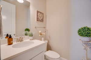 Half bathroom featuring vanity and toilet