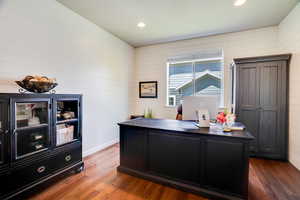 Home office with wood-type flooring, wood walls, and recessed lighting