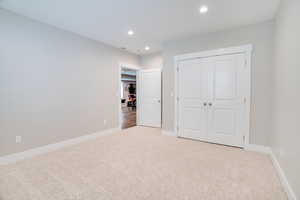 Unfurnished bedroom with carpet floors, a closet, and recessed lighting
