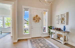 Foyer entrance with a chandelier and light wood-type flooring