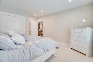 Bedroom featuring recessed lighting, carpet flooring, and a closet