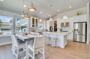 Dining area featuring vaulted ceiling, recessed lighting, and light wood-style floors