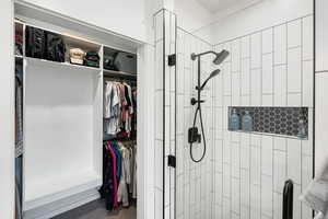 Ensuite bathroom featuring a spacious closet and a shower stall