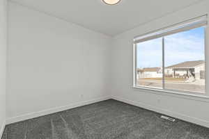 Bedroomwith baseboards and dark colored carpet