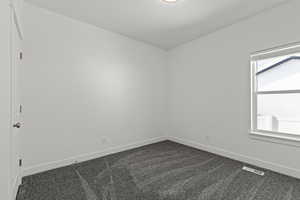 Bedroom featuring baseboards and dark colored carpet