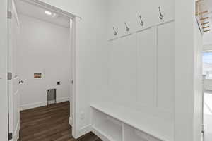 Mudroom and laundry room  featuring dark wood-style flooring and recessed lighting