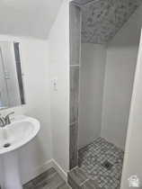 Bathroom featuring wood finish floors, a stall shower, and lofted ceiling