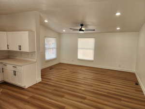 Unfurnished dining area with dark wood-style floors, a ceiling fan, lofted ceiling, and recessed lighting
