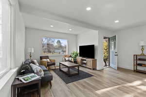 Living area featuring light wood finished floors and recessed lighting
