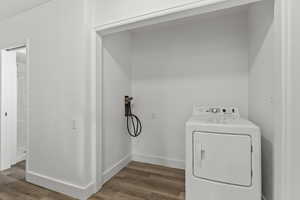 Laundry area with washer / dryer and wood finished floors