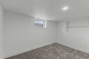 Below grade area featuring dark carpet and built in features