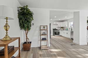 Living room with light wood-style floors and recessed lighting