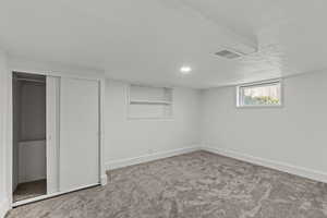Below grade area with carpet flooring and a textured ceiling