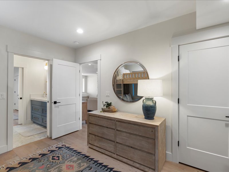Bedroom with light wood finished floors, ensuite bathroom, and recessed lighting
