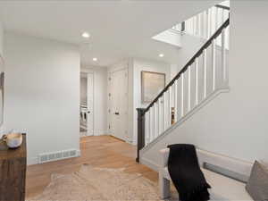 Entrance foyer with stairway, light wood-style floors, recessed lighting, and washing machine and clothes dryer