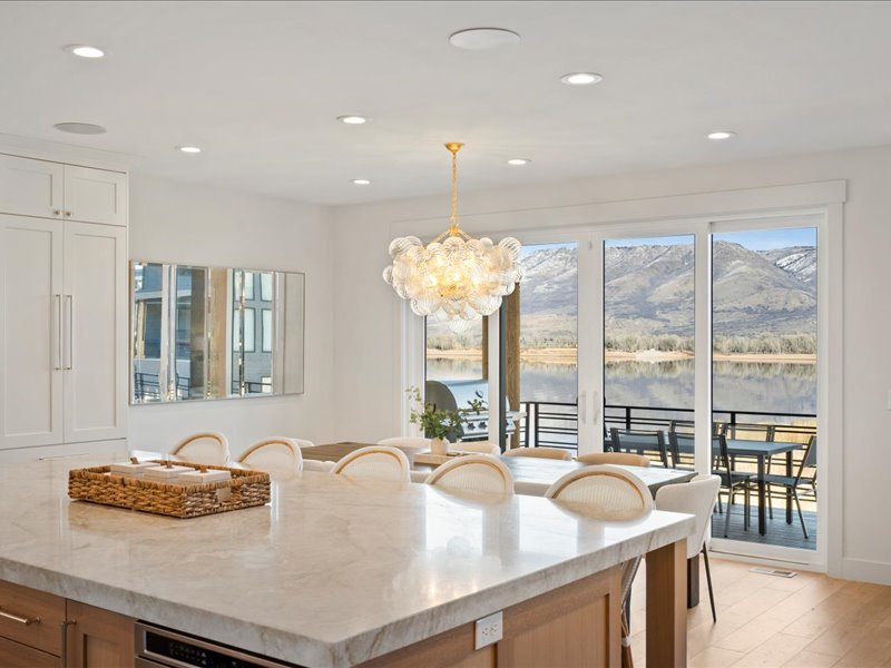 Kitchen with light stone counters, hanging light fixtures, a chandelier, plenty of natural light, and recessed lighting