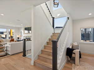 Stairs with recessed lighting, wood-type flooring, and a fireplace