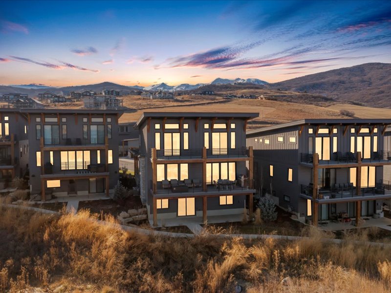 Rear view of property featuring a mountain view, a balcony, and a patio