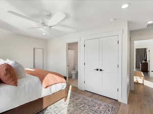 Bedroom with recessed lighting, a closet, wood finished floors, ceiling fan, and connected bathroom
