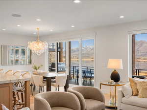 Living area featuring a chandelier, recessed lighting, healthy amount of natural light, light wood-style flooring, and a water and mountain view