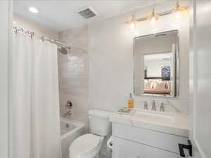 Full bathroom featuring shower / bathtub combination with curtain, vanity, and connected bathroom