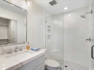 Bathroom with vanity, a stall shower, and recessed lighting