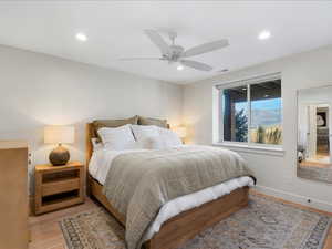 Bedroom with light wood-style flooring, a ceiling fan, and recessed lighting