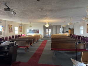 Miscellaneous room featuring a chandelier, plenty of natural light, and a textured ceiling