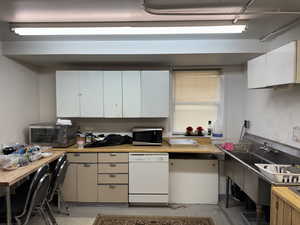 Kitchen featuring white dishwasher, white cabinetry, and stainless steel microwave