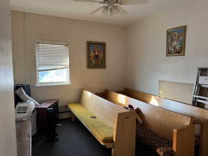 Bedroom featuring a ceiling fan and dark carpet