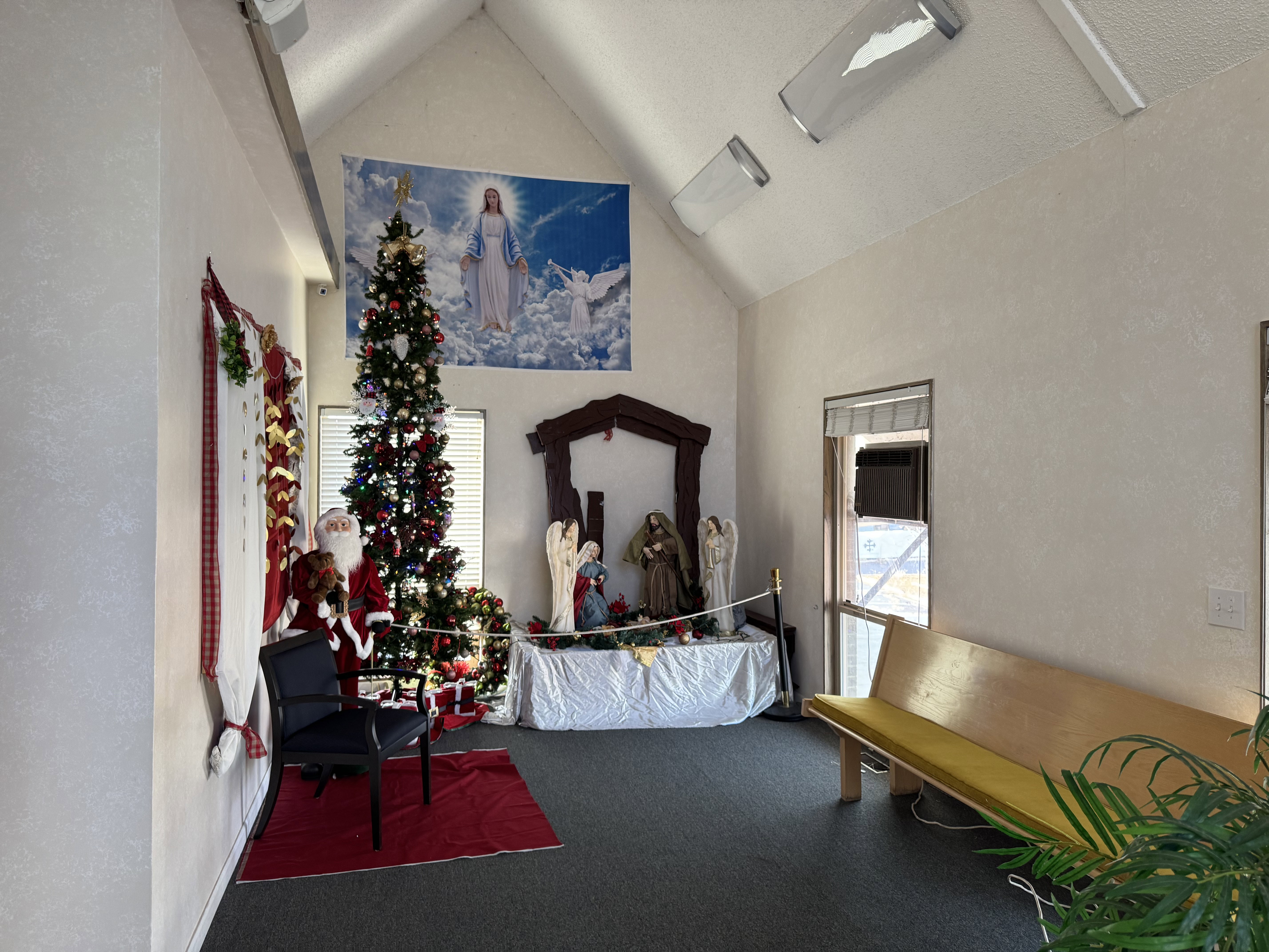 Living area featuring a textured wall, plenty of natural light, and high vaulted ceiling