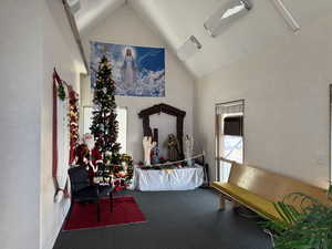Living area featuring a textured wall, plenty of natural light, and high vaulted ceiling