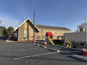View of building exterior featuring uncovered parking